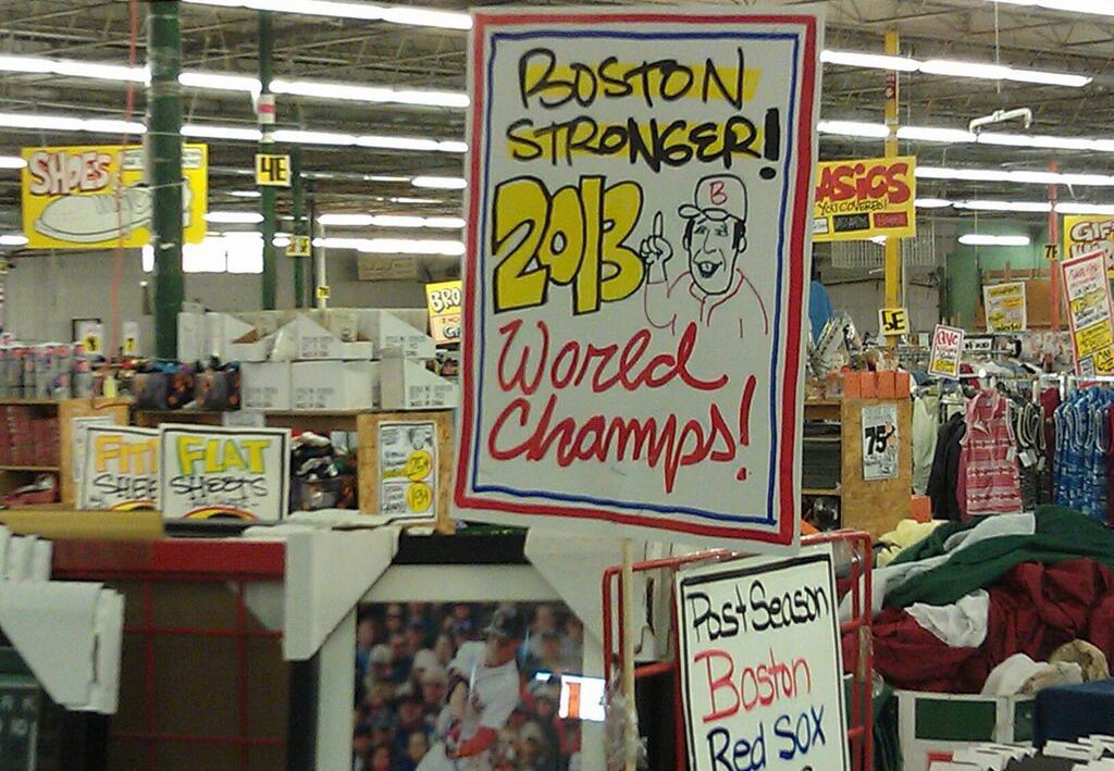 Sign in a store celebrating the Boston Red Sox's 2013 World Series championship with the phrase 'Boston Stronger!' and a drawing of a cheering fan.
