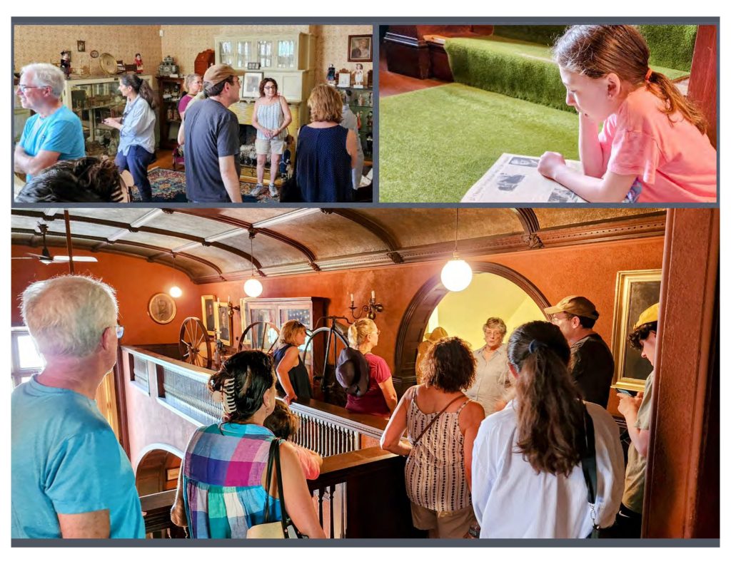 A group of visitors on a guided tour inside the F. Holland Day House, observing period furnishings and historical details. The tour guide engages participants in a discussion about the home's history.