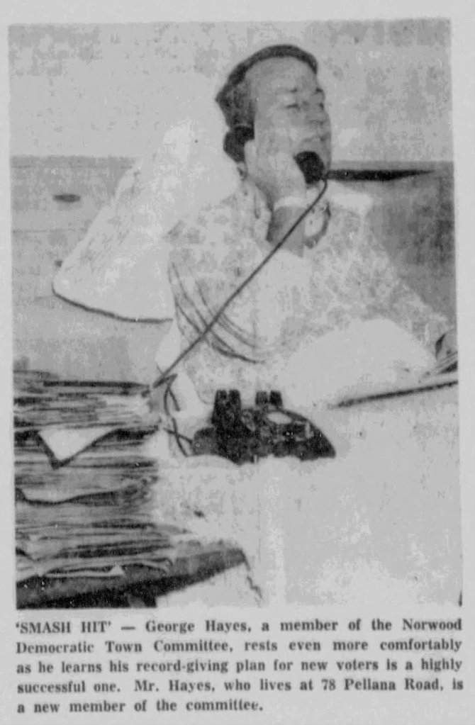 George Hayes, a member of the Norwood Democratic Town Committee, sitting with a phone to his ear, surrounded by paperwork.