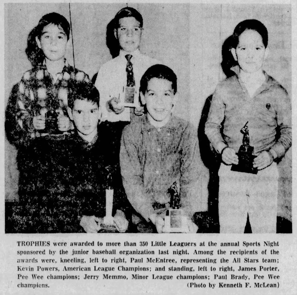 Group of five boys posing with trophies at a sports awards event, featuring a mix of expressions and attire.