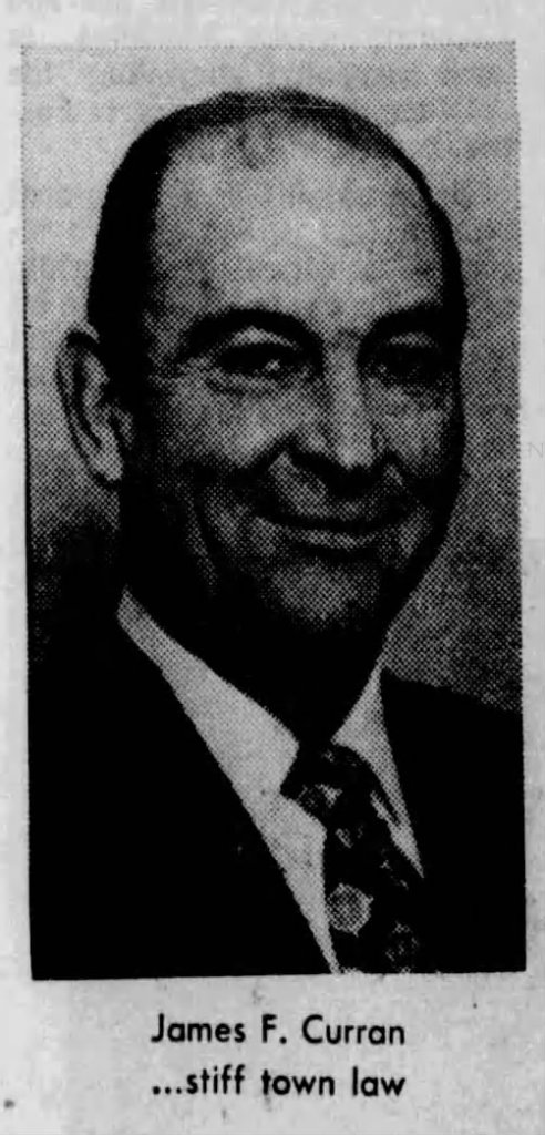 Black and white portrait of James F. Curran, featuring a smiling man in a suit and tie.